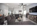 Comfortable living room features a large sectional sofa, ceiling fan, and modern decor with tile floors at 1553 Bright View Dr, Las Vegas, NV 89119
