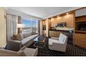 Modern living area featuring city views from a large window, a wet bar, and stylish, comfortable seating at 2000 N Fashion Show Dr # 5417, Las Vegas, NV 89109
