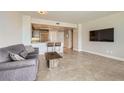 Open living room featuring a modern kitchen, tile floors, comfortable seating, and a large screen TV at 222 Karen Ave # 2305, Las Vegas, NV 89109