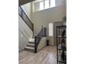 Bright entryway features tall ceilings, staircase with wood railing, and wood-look floors at 2645 Cava Tirreni St, Henderson, NV 89044