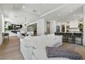 Open-concept floorplan boasts hardwood floors, a white sofa, and dining area with modern lighting at 2797 Turtle Head Peak Dr, Las Vegas, NV 89135
