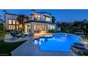 Backyard oasis boasts a pool, jacuzzi, outdoor seating, and beautiful landscaping for ultimate relaxation and entertainment at 2837 Turtle Head Peak Dr, Las Vegas, NV 89135