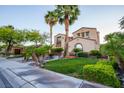 Elegant two-story home with desert landscaping, palm trees, and attached three-car garage at 2837 Turtle Head Peak Dr, Las Vegas, NV 89135