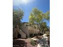 Well-maintained condo building with mature trees and sidewalks under a clear blue sky at 3055 Key Largo Dr # 204, Las Vegas, NV 89120
