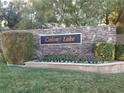 Landscaped entrance to Colony Lake community with stone wall, manicured hedges and sign at 35 Emerald Dunes Cir, Henderson, NV 89052