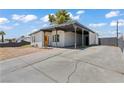Single-story house with a large driveway, covered parking and sunny yellow front door at 3684 Hawaii Ave, Las Vegas, NV 89104