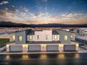 Rear exterior view of townhome showing multiple attached garages and twilight sky at 6197 Hibiscus Garden St # 177, North Las Vegas, NV 89081