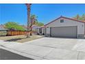 Attractive one-story home featuring a tile roof, 2-car garage, long driveway, and desert landscaping at 715 Heritage Point Dr, Henderson, NV 89002