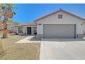 Inviting one-story home showcasing a 2-car garage, tile roof, desert landscaping and cozy entryway at 715 Heritage Point Dr, Henderson, NV 89002