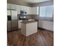 A bright kitchen features an island, stainless steel appliances, and ample counter space for culinary enthusiasts at 7160 Mineral Park Ave, Las Vegas, NV 89179