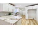 Modern kitchen features white cabinets, quartz countertops, stainless steel appliances, and wood flooring at 744 Hubbard St, Las Vegas, NV 89110