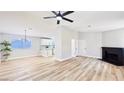 Bright living room featuring wood-look floors, modern ceiling fan, and stylish black brick fireplace at 744 Hubbard St, Las Vegas, NV 89110