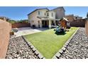Spacious backyard featuring artificial turf, a patio area, and a playground with brick perimeter at 7468 Wellfleet Bay Ave, Las Vegas, NV 89179