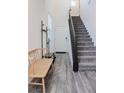 Inviting entryway features sleek gray floors, stairs, and a cozy bench, leading to a bright and welcoming home at 7468 Wellfleet Bay Ave, Las Vegas, NV 89179