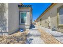 Well-maintained side exterior featuring stone walkway with desert landscaping for a modern look at 7533 Garnet Moon St, North Las Vegas, NV 89084