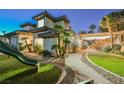 Expansive backyard featuring a play area, pool with waterfall, plus a covered patio with string lights at 764 Ricota Ct, Henderson, NV 89012