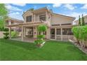 Well-maintained backyard with lush green grass, a covered patio, and mature landscaping at 7837 Sea Rock Rd, Las Vegas, NV 89128