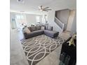 Comfortable living room featuring tile flooring, a ceiling fan, and a gray sectional sofa at 7990 Formitch Ct, Las Vegas, NV 89166