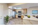 Modern kitchen with stainless steel appliances, light wood cabinets, and a breakfast bar with marble countertops at 8070 W Russell Rd # 1046, Las Vegas, NV 89113