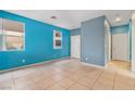 Bright living room with tile flooring, large windows and freshly painted blue walls at 8509 W Rochelle Ave, Las Vegas, NV 89147