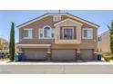 Neutral townhome featuring attached garages, tan stucco, and a charming balcony with a metal railing at 8639 Horizon Wind Ave # 102, Las Vegas, NV 89178
