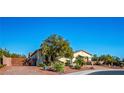Attractive single-story home showcasing desert landscaping, a large tree, and a brick driveway at , Las Vegas, NV 89131