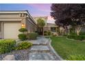 Charming front yard featuring lush landscaping, a stone walkway, and a well-maintained lawn leading to the front door at 1016 Sable Mist Ct, Las Vegas, NV 89144