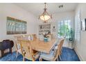 Elegant dining room featuring a decorative chandelier, blue rug, and bright, natural lighting at 10320 Luxembourg Ave, Las Vegas, NV 89145