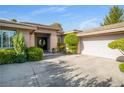 Charming home exterior showcasing well-maintained landscaping and attached two car garage at 10320 Luxembourg Ave, Las Vegas, NV 89145