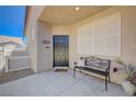 Cozy front porch with black front door, adorned with an iron bench and potted plants at 1076 Crescent Falls St, Henderson, NV 89011
