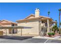 Condo building featuring stucco siding, carport parking, and well-maintained grounds at 1201 N Buffalo Dr # 202, Las Vegas, NV 89128