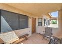 Private covered patio featuring tile flooring, wood bench, and comfortable seating area at 1201 N Buffalo Dr # 202, Las Vegas, NV 89128