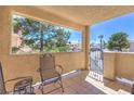 Cozy outdoor patio with a view and metal chairs overlooking the complex and mature trees at 1201 N Buffalo Dr # 202, Las Vegas, NV 89128