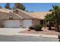 Inviting single-story home with two-car garage, desert landscaping, and a tile roof at 241 Honeywood St, Henderson, NV 89074
