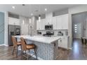 Bright, modern kitchen with a large island, white cabinetry, stainless steel appliances, and stylish pendant lights at 2530 Catallo St, Henderson, NV 89044