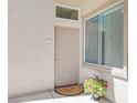 Charming front door with neutral paint, decorative flower pot, and unit number with a small window above at 3451 Desert Cliff St # 103, Las Vegas, NV 89129
