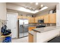 Bright kitchen with stainless steel appliances, light wood cabinets, and countertop open to the dining area at 3451 Desert Cliff St # 103, Las Vegas, NV 89129