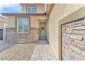 Close-up of the house's inviting front door and charming stone facade with desert landscaping at 4332 Stardusk Falls Ave, North Las Vegas, NV 89084