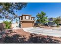 Two-story home features a circular driveway, two-car garage and desert landscaping at 4512 Long Horse Ct, Las Vegas, NV 89147