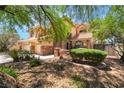 Charming two-story home with stone accents, mature trees, and manicured landscaping creating inviting curb appeal at 5225 Sandy Cactus Ln, Las Vegas, NV 89149