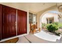 Inviting covered front porch with a decorative wood bench and beautiful wood door at 532 Kavanagh Pl, Las Vegas, NV 89123