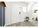 Inviting entryway featuring wood-look tile flooring, a crisp white door, and a charming accent plant at 551 Swiss Cottage Ave, Las Vegas, NV 89178
