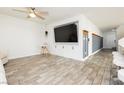 Open-concept living area with a built-in entertainment center and stylish wood-look tile flooring throughout at 551 Swiss Cottage Ave, Las Vegas, NV 89178