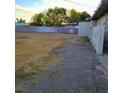 This backyard has a large vacant lot with a block wall and grass and gravel at 5617 Alfred Dr, Las Vegas, NV 89108