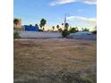 Large, vacant lot with a block wall and palm trees visible in the background at 5617 Alfred Dr, Las Vegas, NV 89108