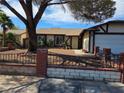 Single-story home with desert landscaping, wrought iron fence and a two-car garage, offering curb appeal and convenience at 6402 Agua Dr, Las Vegas, NV 89103