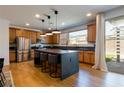 Spacious kitchen featuring wood cabinets, stainless steel appliances, and a large island with bar seating at 6927 Desert Finch St, North Las Vegas, NV 89084