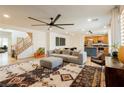 Open-concept living room with hardwood floors, a modern sofa, and access to the kitchen at 6927 Desert Finch St, North Las Vegas, NV 89084