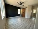 Bright bedroom with sliding barn doors, modern ceiling fan and light gray plank flooring at 7537 Brisa Del Mar Ave, Las Vegas, NV 89179