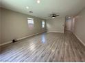 Spacious living room with gray tone plank flooring and modern ceiling fan at 7537 Brisa Del Mar Ave, Las Vegas, NV 89179
